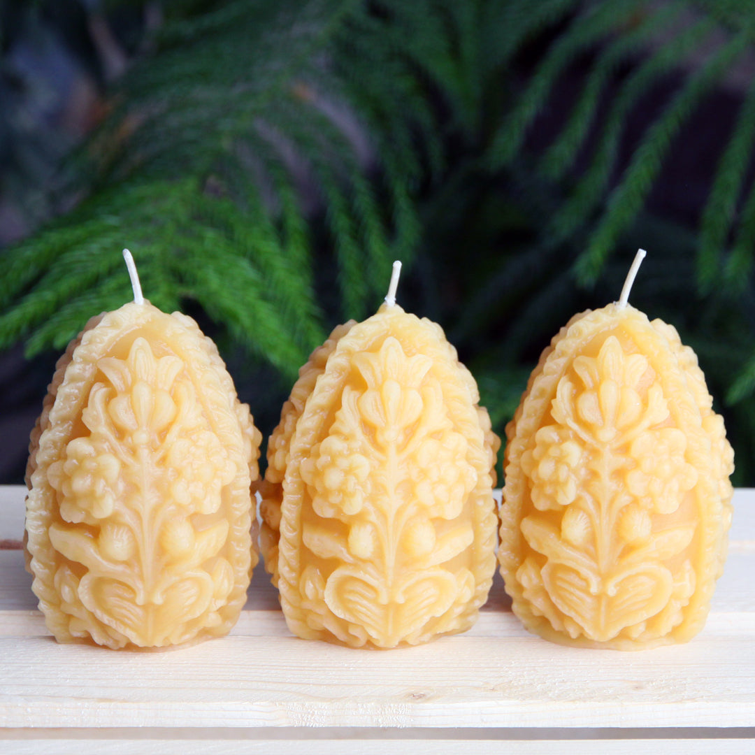 A trio of decorative beeswax egg candles